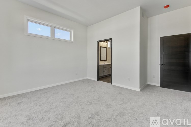 A room with a carpeted floor and a door leading to another room.