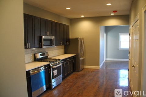 A kitchen with dark wood cabinets and stainless steel appliances.
