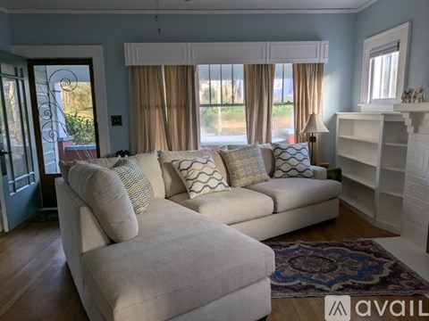 A living room with a large sectional sofa and a rug.