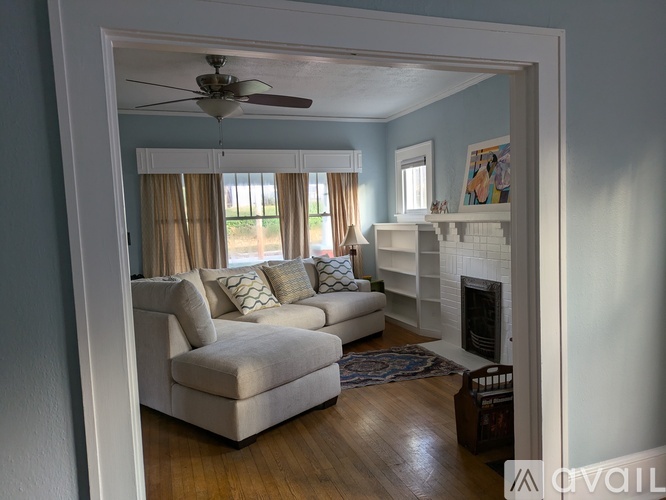 A living room with a white couch and a fireplace.