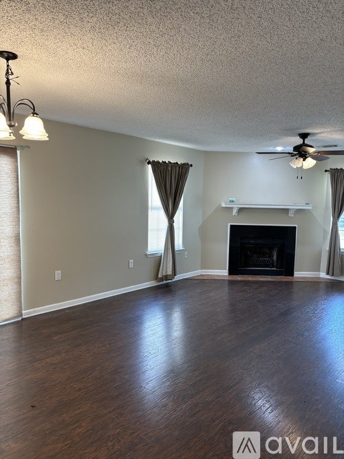A living room with a fireplace and a fan.