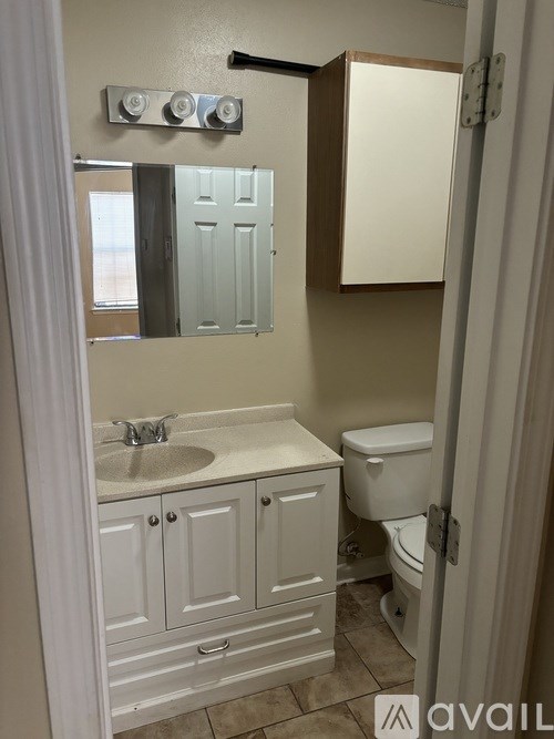 A bathroom with a sink, toilet, and medicine cabinet.
