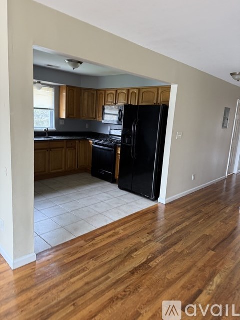 A kitchen with black appliances and wooden cabinets.
