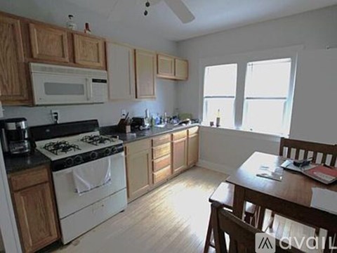 A kitchen with wooden cabinets and a white stove top oven.