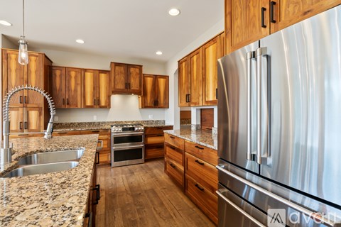 A modern kitchen with wooden cabinets and stainless steel appliances.