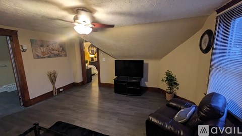 A living room with a black leather couch and a television.