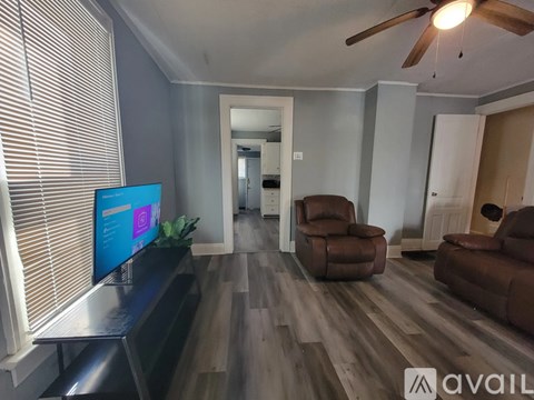 A living room with a television and two chairs.