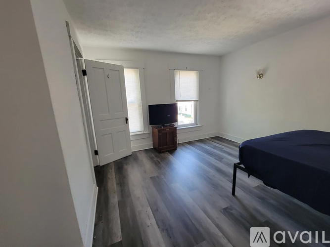 A bedroom with a bed, dresser, and window.
