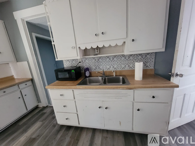 A kitchen with white cabinets and a wooden countertop.