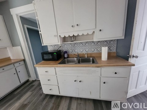 A kitchen with white cabinets and a wooden countertop.