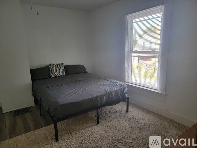 A bedroom with a bed and a window.