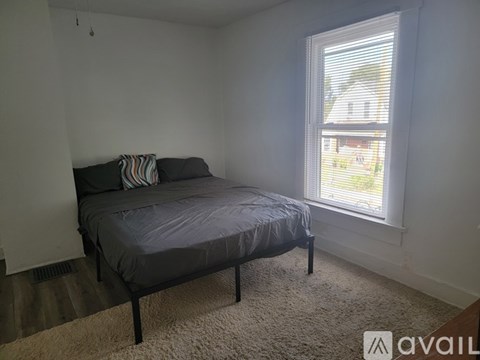 A bedroom with a bed and a window.
