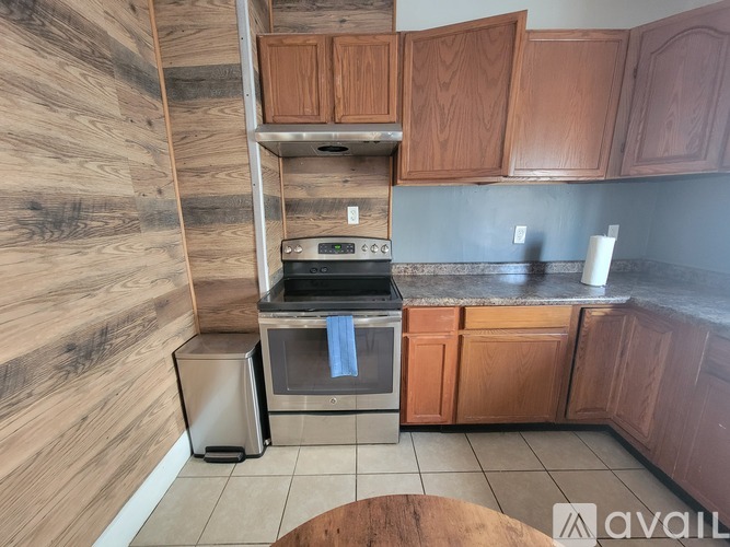 A kitchen with wooden cabinets and a stainless steel oven.