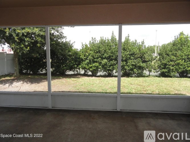 A room with a view of trees through the window.