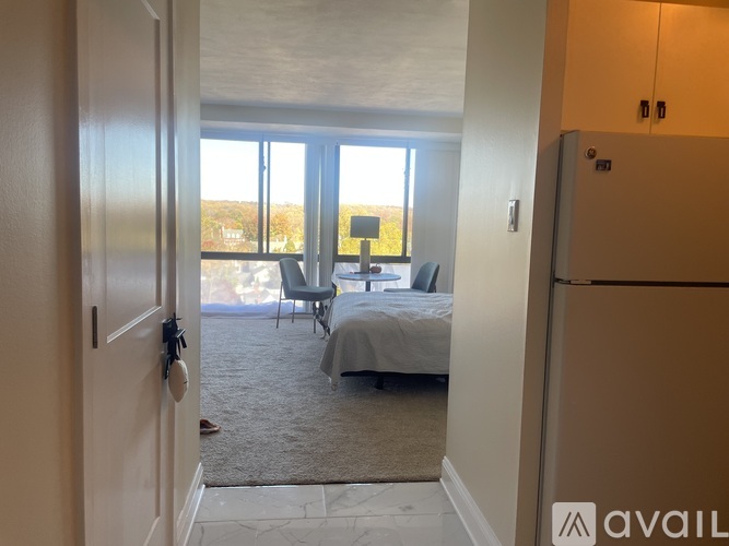 A bedroom with a bed, chair, and sliding glass doors.
