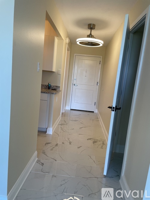 A hallway with marble flooring and a white door.