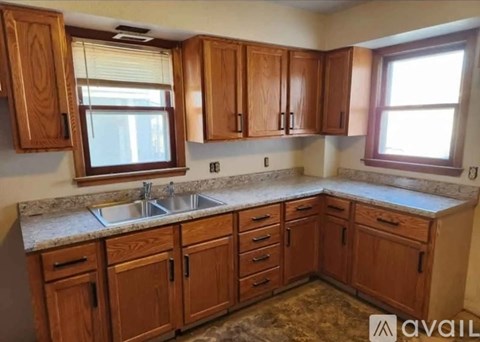 A kitchen with wooden cabinets and a granite countertop.