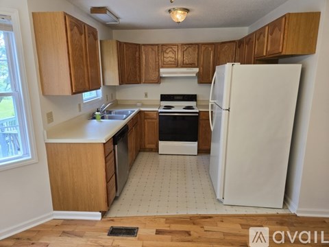 A kitchen with wooden cabinets and a white refrigerator.