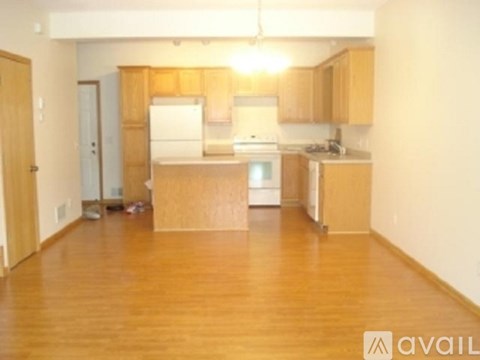 A kitchen with wooden cabinets and a white fridge.