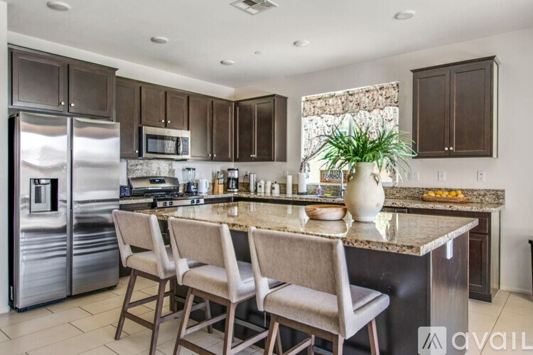 A kitchen with a granite countertop and stainless steel appliances.