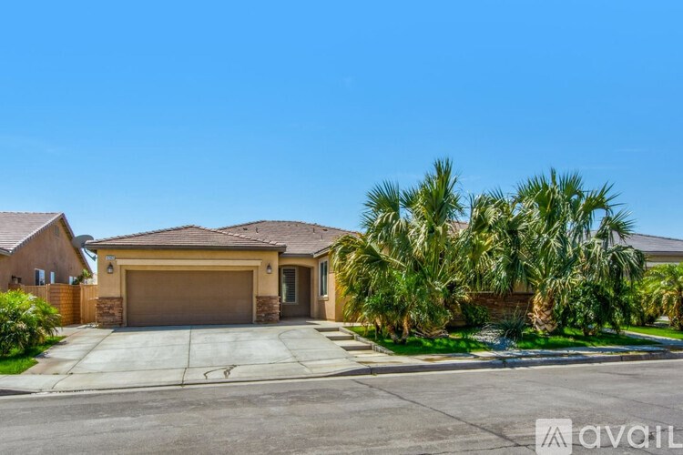 A house with a garage and palm trees in front.