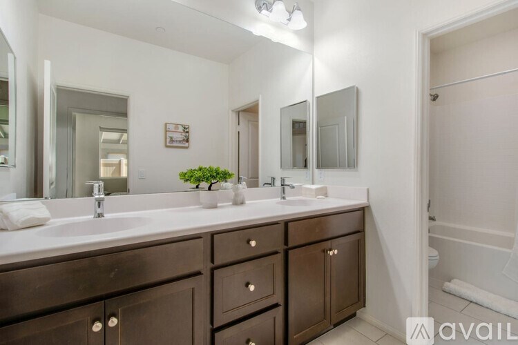 A bathroom with a white countertop and brown cabinets.