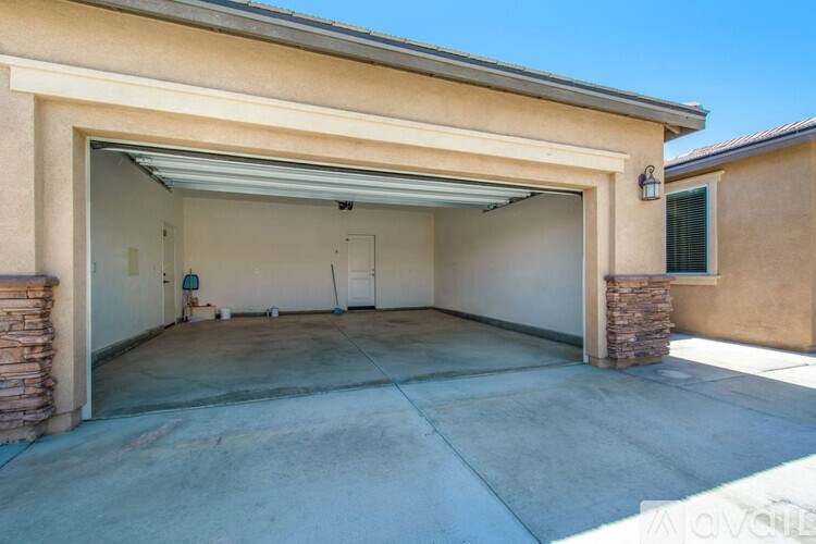 A garage with a white door and a stone pillar.