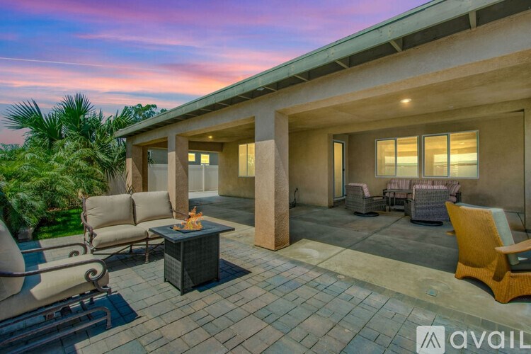 A patio with a fire pit and chairs is available for rent.