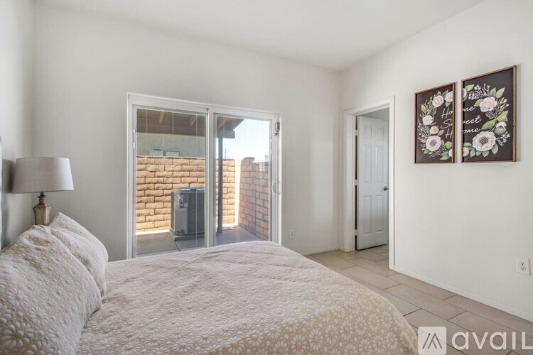A bedroom with a bed, lamp, and two pictures on the wall.