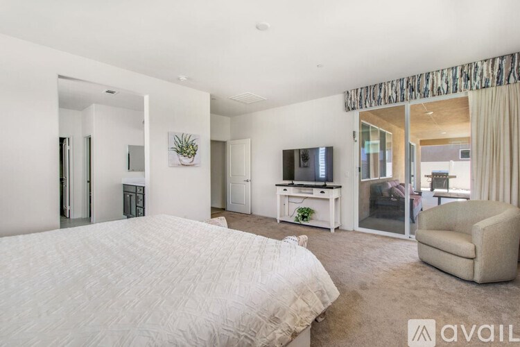 A bedroom with a large bed and a television in the corner.