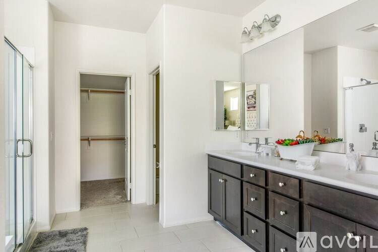 A bathroom with a sink, mirror, and a large open door.