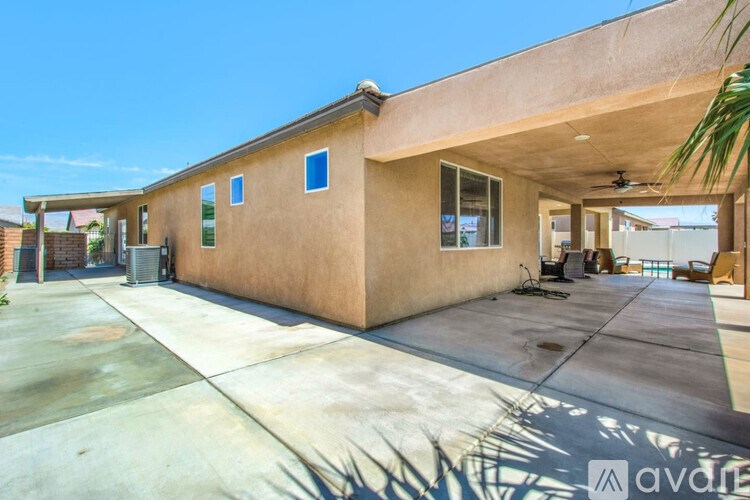 A house with a concrete driveway and a covered patio area.