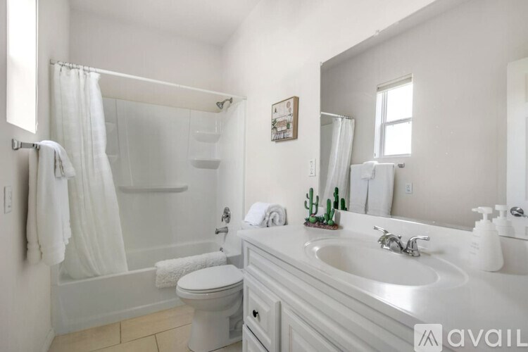 A bathroom with a white toilet, sink, and bathtub.