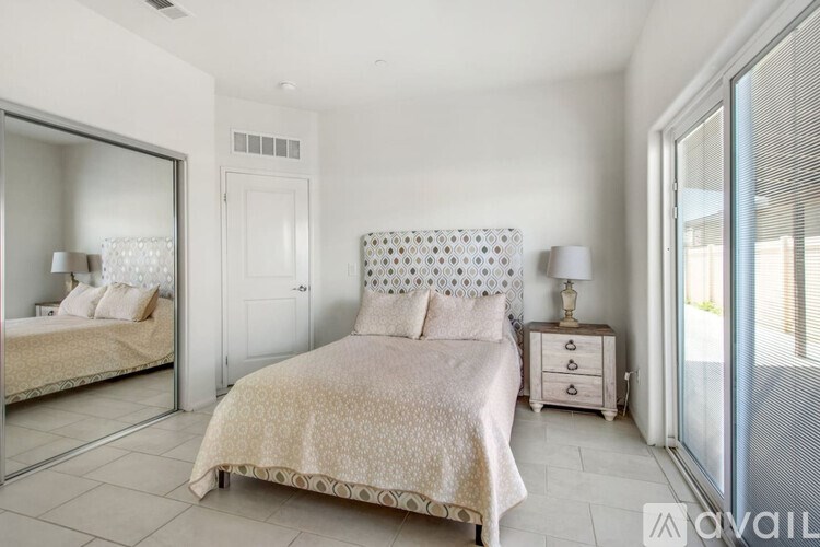 A bedroom with a large bed and a mirror on the wall.