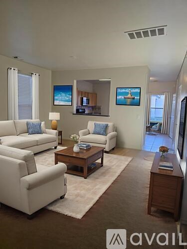 A living room with white furniture and a flat screen TV.
