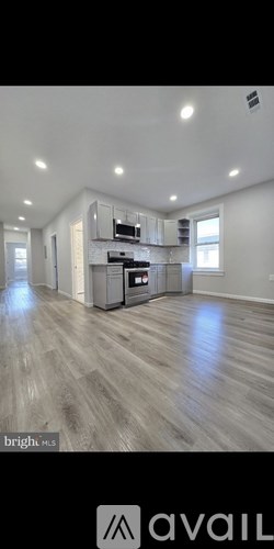 A spacious kitchen with a stove top oven and a refrigerator.