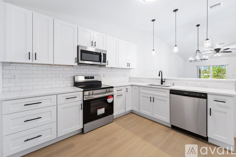 A kitchen with white cabinets and a black stove top oven.