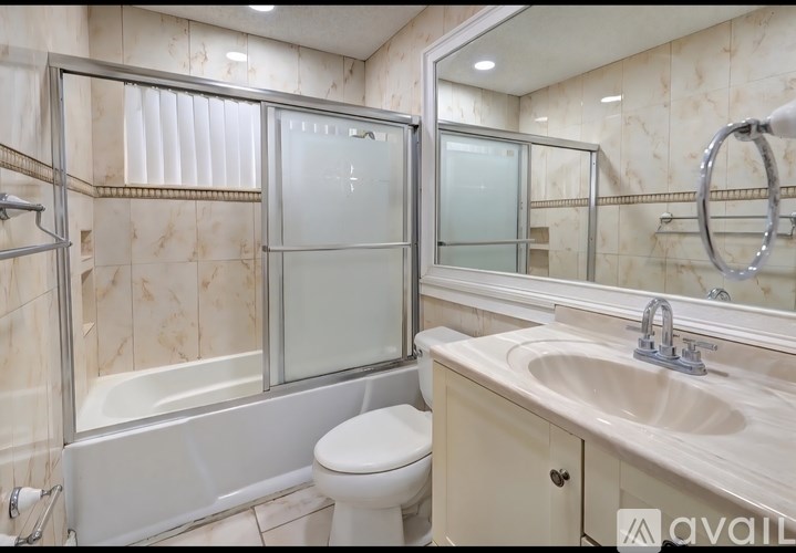 A bathroom with a toilet, sink, and shower.