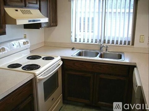 A kitchen with a white stove top oven and a white microwave above it.