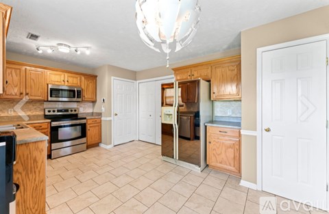 A kitchen with wooden cabinets and a black fridge.