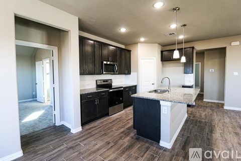 A kitchen with black cabinets and a granite countertop.