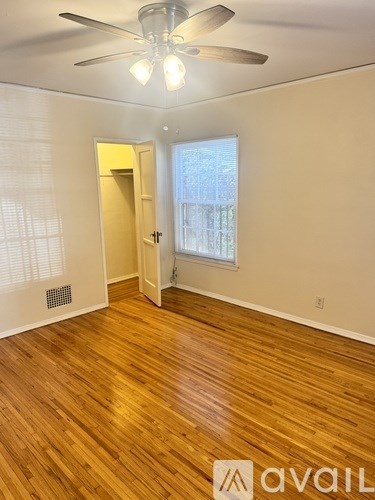A room with wooden floors and a ceiling fan.