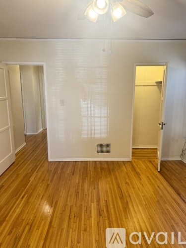 A room with wooden floors and a ceiling fan.