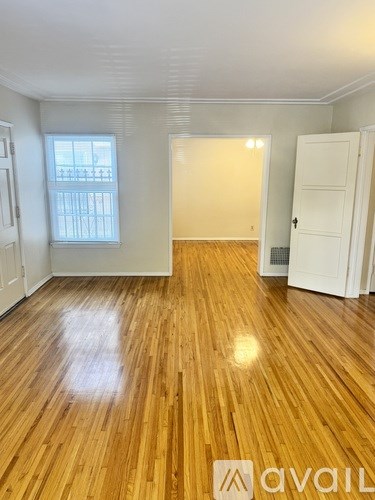 A room with wooden flooring and white walls.