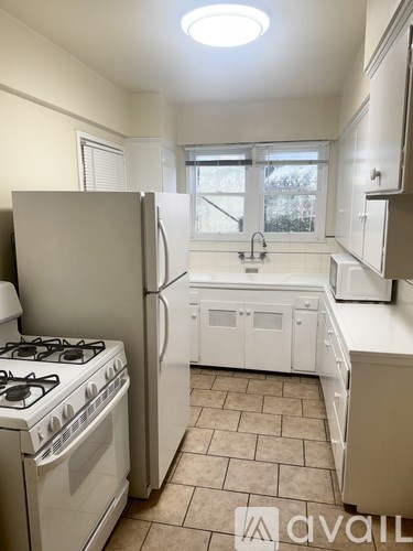 A kitchen with a white stove and refrigerator.