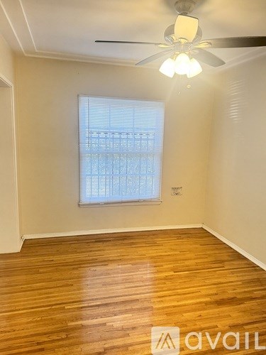 A room with wooden floors and a ceiling fan.