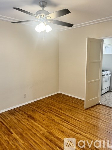 A room with a ceiling fan and wooden flooring.