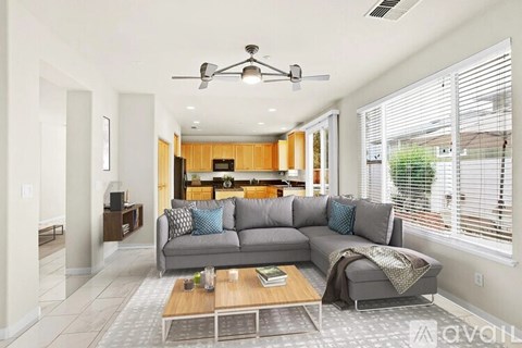 A living room with a grey couch and a wooden coffee table.
