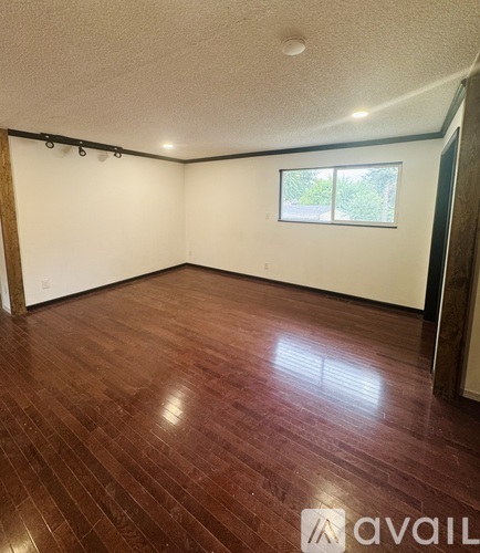 A room with wooden flooring and a window.