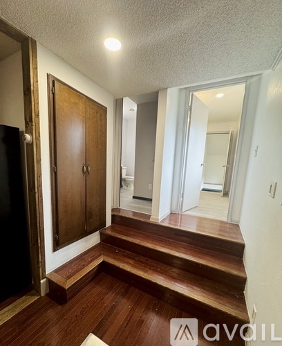 A hallway with a wooden floor and a wooden door.